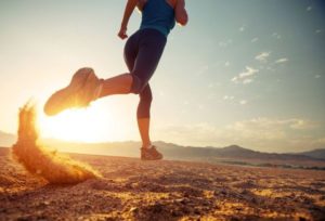 Young lady running in the desert at sunset